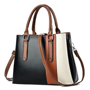 Elegant tri-color faux leather handbag in black, brown and cream with metal rivets