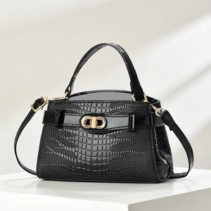 Elegant black crocodile-pattern handbag with gold CD clasp on white display stand