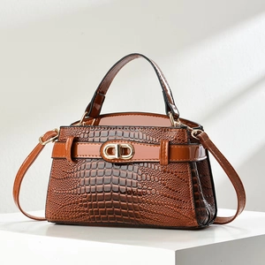 Detail of caramel crocodile embossed leather bag with gold metal CD hardware and handle