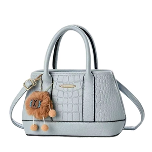Borsa a mano azzurra con trama a pietra, motivo coccodrillo e ciondolo a forma di leone