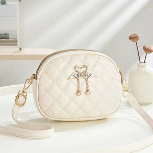 Minimalist white quilted small round crossbody bag with swan heart metal pendant