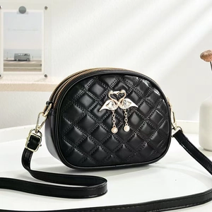 Black quilted mini crossbody bag with swan ornament and pearl tassel on white background