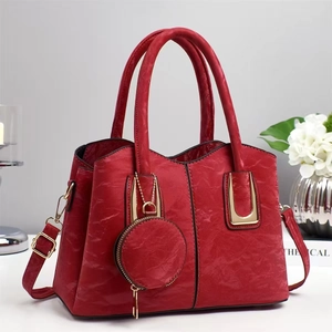 Detail of red soft leather handbag with pleated texture and golden metal hardware