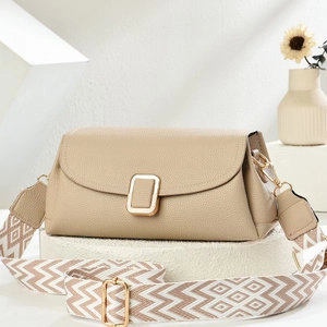 Detail of beige litchi leather bag with gold buckle and woven canvas shoulder strap