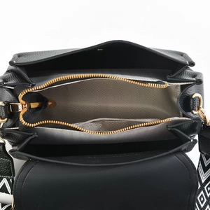 Detail view of black pebble leather bag with zipper pocket and geometric strap