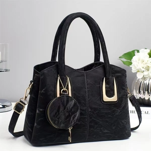 Minimalist black faux leather handbag with gold U-buckle and small round coin purse