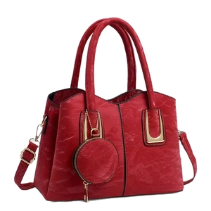 Red embossed faux leather tote bag with pleated texture and adjustable gold-tone strap