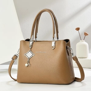 Brown lychee leather tote bag with silver hardware and decorative charm pendant