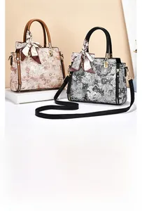 Detail of vintage floral embroidery handbags with silk scarf handle and gold hardware