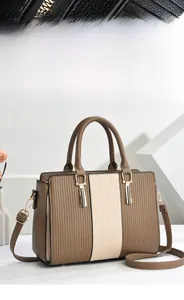 Dettaglio dell'hardware dorato e pelle pieghettata su borsa tote bicolore minimalista