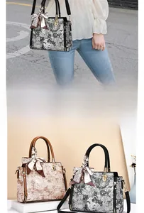 Detail of vintage floral textured handbag with silk scarf handle and gold hardware