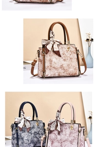 Macro view of retro floral print handbag with silk scarf handle and gold hardware detail