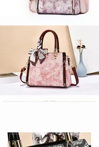 Detail view of pink floral handbag with silk scarf, brown handles and gold hardware