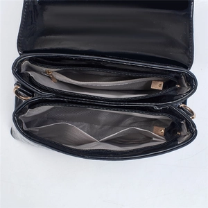 Detailed interior of crocodile pattern bag showing dual compartments and herringbone lining