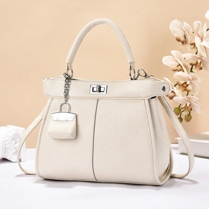 Detail van crème wit lychee leer en de zilveren draaisluiting op deze luxe handtas