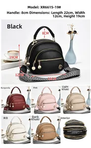 Detail of multi-zipper textured leather crossbody bag showing striped woven strap and size info
