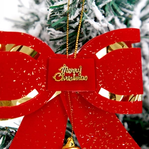 Red Christmas velvet bow with gold Merry Christmas sign on a snowy tree branch