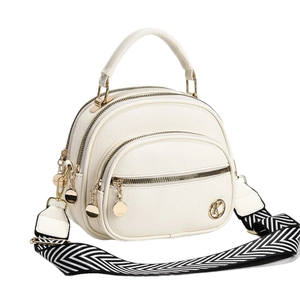 Beige textured crossbody bag with multi-zipper compartments and wide woven strap