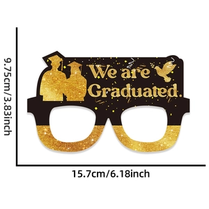 Close-up of black and gold graduation paper glasses with glitter finish and text details