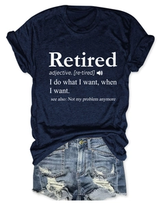 Détail du texte Retired sur un t-shirt bleu marine et un short en jean délavé avec trous