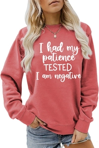 Détail de l'imprimé slogan sur un sweat à manches longues rouge foncé à col rond
