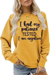 Détail du sweat jaune ample avec imprimé lettres noires 'I had my patience TESTED'