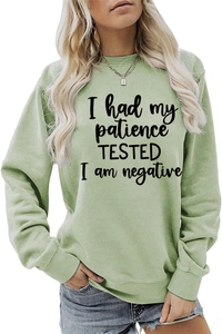 Détail de l'imprimé humoristique sur le sweat-shirt vert sauge à col rond pour femme