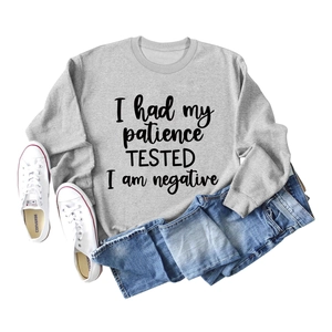 Vue à plat d'un sweat gris à manches longues avec slogan 'I had my patience TESTED'