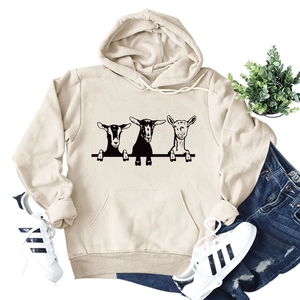 Detail of loose beige hoodie featuring cute goat prints and functional kangaroo pocket