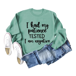 Détail du sweat-shirt vert sauge avec inscription noire I Had My Patience Tested et col rond