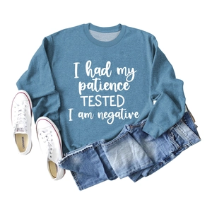 Détail du sweat-shirt bleu-gris avec texte blanc imprimé présenté à plat sur fond blanc