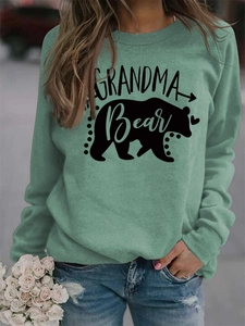 Close-up of GRANDMA Bear letter print and black bear silhouette on sage green sweatshirt