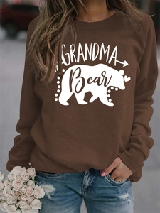 Detail of Grandma Bear print on brown long sleeve sweatshirt worn with blue jeans