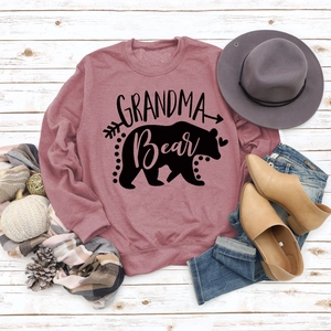 Close-up of Grandma Bear print on a dusty rose sweatshirt with autumn fashion accessories