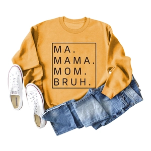 Flat lay of mustard yellow oversized sweatshirt with black text and denim pants