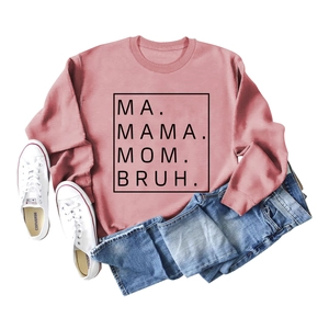 Pink crewneck sweatshirt with MA MAMA MOM BRUH print laid flat with denim jeans