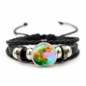 Macro shot of bohemian woven bracelet with galaxy moon glass cabochon and metal beads