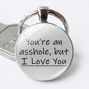 Macro detail of round funny couple keychain with engraved love quote and brushed metal finish