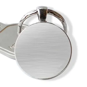 Close-up of a round silver keychain with humorous quote and black lettering detail