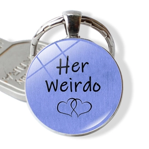 Close-up of funny couple keychain with Her Weirdo text and double heart motif