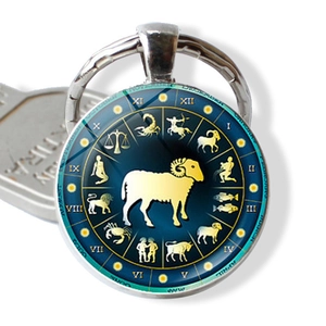 Macro detail of Aries zodiac glass cabochon keychain with gold constellation symbols