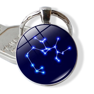 Macro view of Sagittarius constellation glass pendant keychain with polished silver metal base