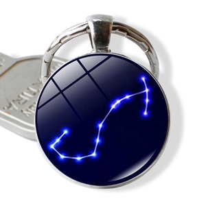 Detail of Scorpio zodiac glass dome keychain with silver metal frame and blue starry design