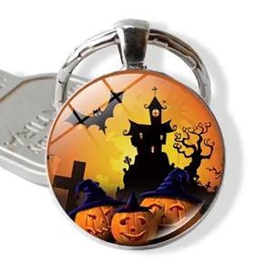 Close-up of Halloween glass pendant keychain featuring pumpkin and castle illustrations
