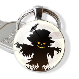 Close-up of Halloween keychain with a glowing scarecrow illustration in glass dome