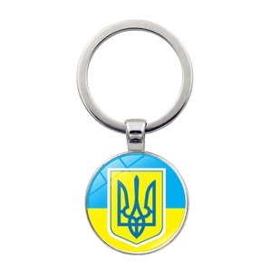Close-up of metal keychain featuring the Ukraine flag and coat of arms on a round pendant