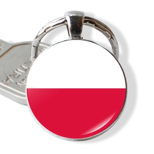 Detail of round Poland flag keychain featuring a glass dome and polished metal frame