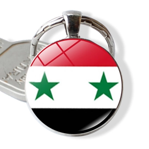 Macro shot of Syria flag glass dome keychain with polished metal alloy rim and key