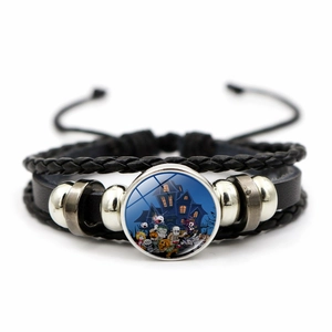 Detail van Halloween gevlochten lederen armband met pompoen en spook bedeltje