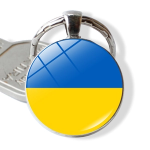 Macro shot of circular keychain with Ukraine flag under a polished glass dome